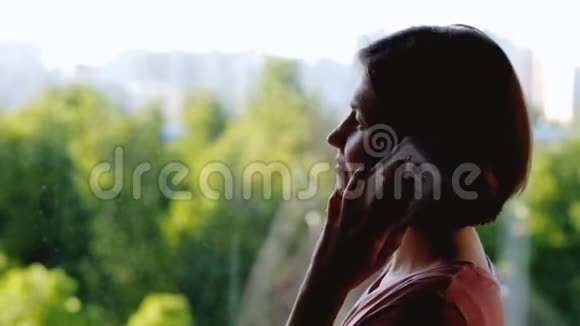 站在窗前说话的女人视频的预览图