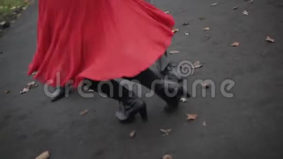 女人穿着红色裙子男人穿着灰色的裤子她的腿跳着探戈视频的预览图