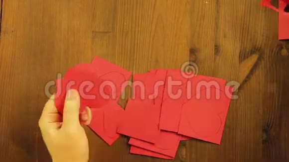 这个女孩从红纸板上剪下各种大小的心时间跨度视频的预览图