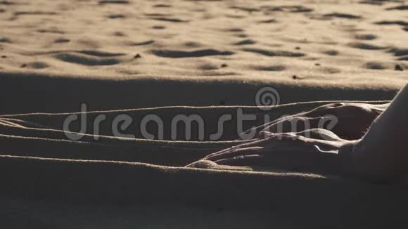 女人手摸着沙滩上的沙子视频的预览图