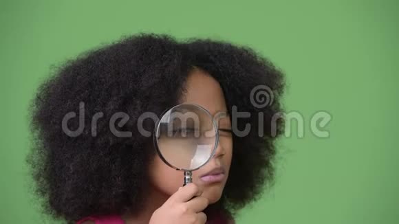 年轻可爱的非洲女孩非洲头发用放大镜视频的预览图