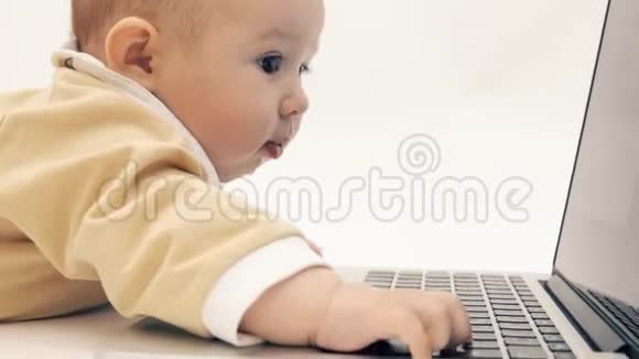 有趣的女婴试图用自己的方式使用笔记本电脑视频的预览图