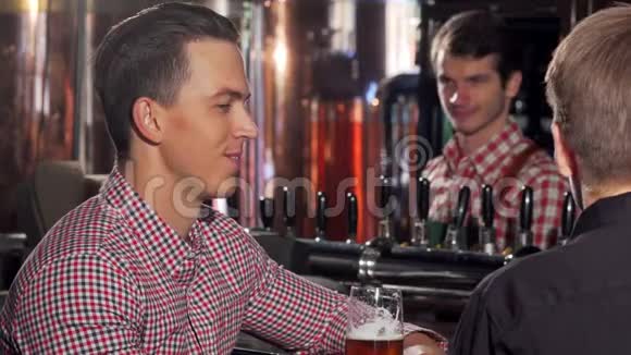 英俊的快乐男人在酒吧和他的朋友聊天喝着美味的啤酒视频的预览图