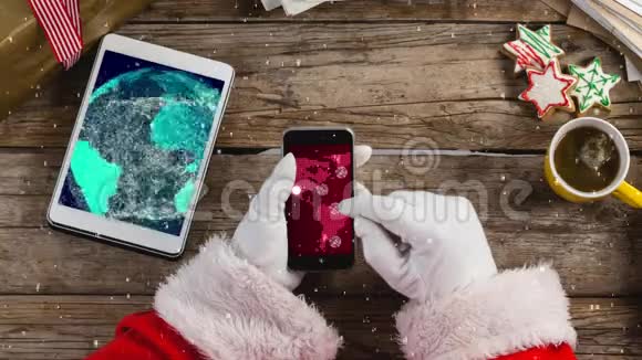 带着智能手机的圣诞老人带着带雪的桌子视频的预览图