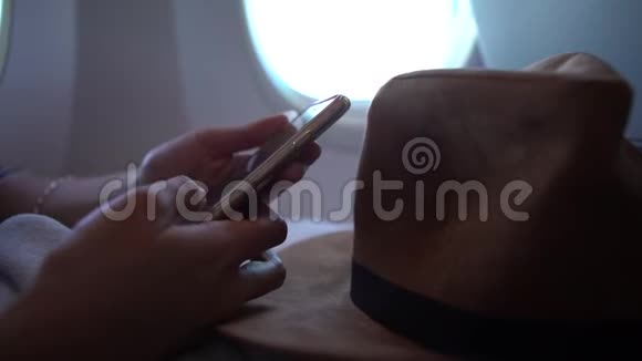 在飞行过程中亚洲妇女用手握着智能手机视频的预览图