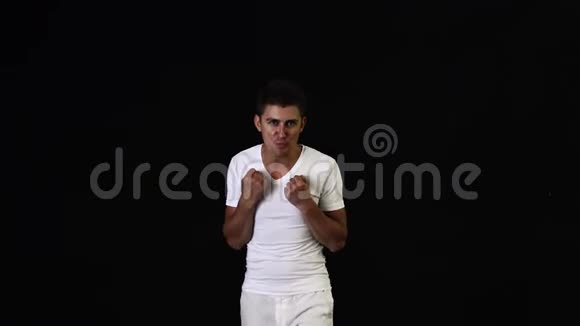 穿着白色t恤和裤子的帅哥在镜头前动情地唱歌视频的预览图