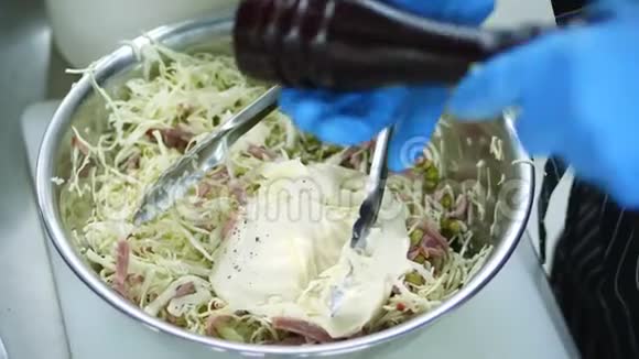 特写用蛋黄酱在金属碗沙拉碗中烹饪蔬菜沙拉厨师把所有的原料混合在一起视频的预览图