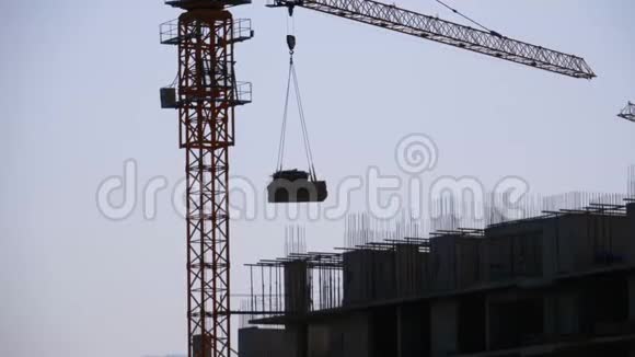 建筑工地上的塔式起重机在高层建筑上起重视频的预览图