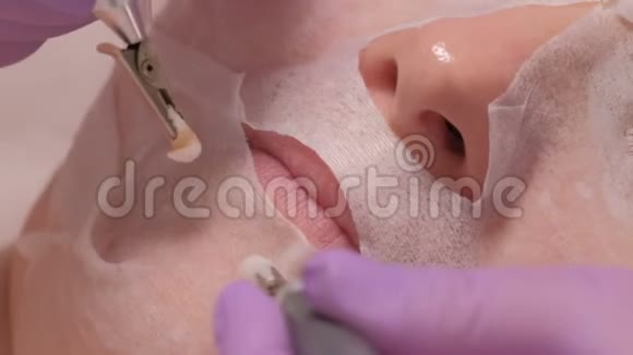 一个戴美容面具的女人在美容院做手术微电流疗法提升除皱美容师的手视频的预览图