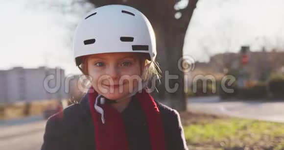 幸福微笑的女儿戴着安全帽的女孩骑着自行车在城市公园画像童年活跃安全视频的预览图