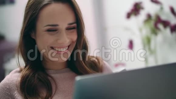快乐女人在笔记本电脑上打视频电话时微笑的肖像视频的预览图