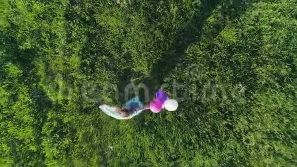 周末快乐留着彩色头发的少女在草坪上玩气球视频的预览图
