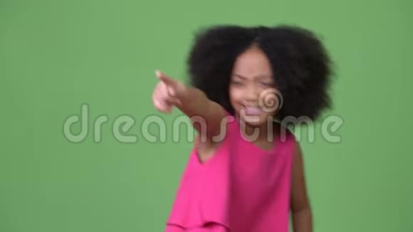 年轻可爱的非洲女孩有非洲头发笑着指指点点视频的预览图
