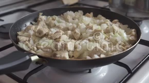 鸡片和切碎的洋葱在锅里煮熟视频的预览图