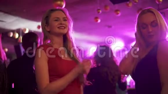 女朋友在人群中的聚会上跳舞两个金发女郎在夜总会的迪斯科舞厅玩得很开心视频的预览图