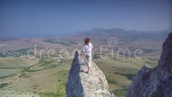 年轻的人走到岩石的年代面对美丽的风景视频的预览图