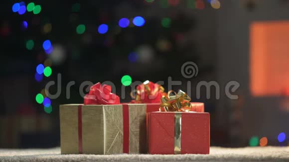三个扭曲的圣诞礼物在地板上灯光闪闪发光的背景假日视频的预览图