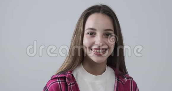 在白人背景下微笑的少女视频的预览图