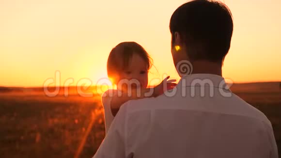 日落时分爸爸抱着快乐的小女儿宝贝在笑一家人晚上在公园散步穿着阳光视频的预览图