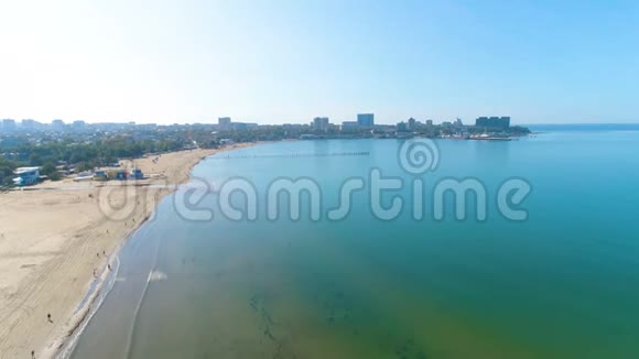 在阳光明媚的日子里在海港沙滩和城市上空进行空中摄影美丽的海景视频的预览图