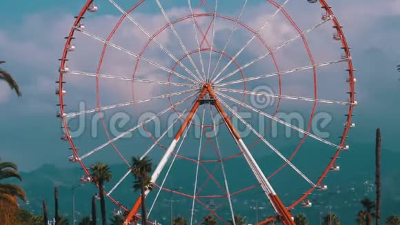 摩天轮对抗蓝天靠近度假镇棕榈树的云晴天视频的预览图