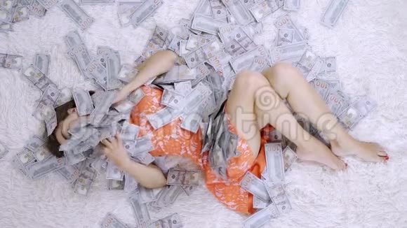 女孩躺在一张白床上赚了很多钱这个女孩很喜欢钱慢动作巨大的财富视频的预览图