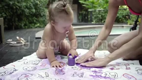 母亲带着孩子在花园的水池边画手指画儿童发展概念4k视频的预览图