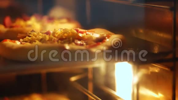 特写在一个大型工业烤箱中用酵母面团烘烤迷你披萨的过程在工业上烤面包视频的预览图