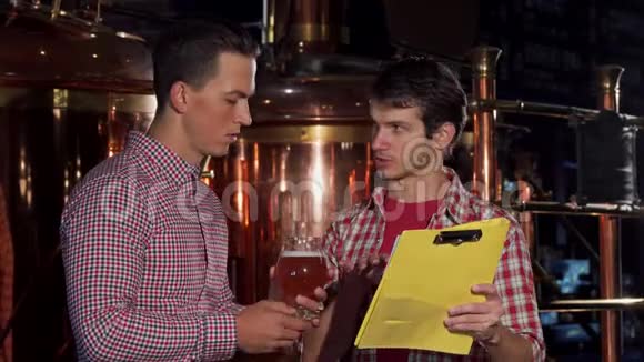 两名酿酒师在酿酒厂检验工艺啤酒视频的预览图
