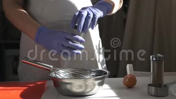 女孩在玻璃碗里用糖搅拌生鸡蛋吹着鸡蛋视频的预览图