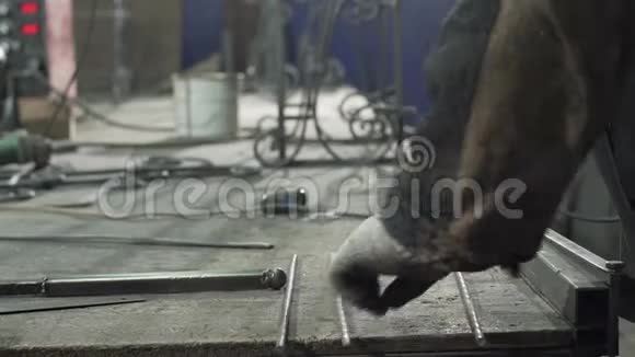 特写一个戴着防护手套的铁匠铺放了两根铁棒视频的预览图