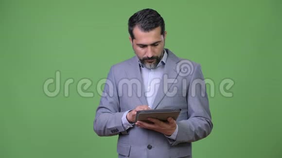 英俊的波斯胡子商人在指导时使用数字平板电脑视频的预览图