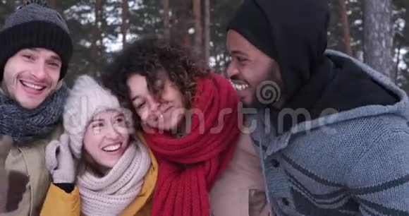 四个朋友穿着暖和的衣服摆姿势视频的预览图