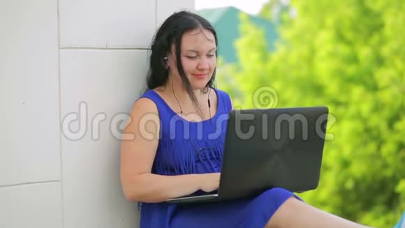 穿蓝色衣服的年轻女子在笔记本电脑上打印文字视频的预览图