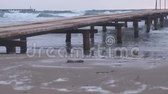 在海滩上生锈的木墩海中风浪日落时美丽海景视频的预览图