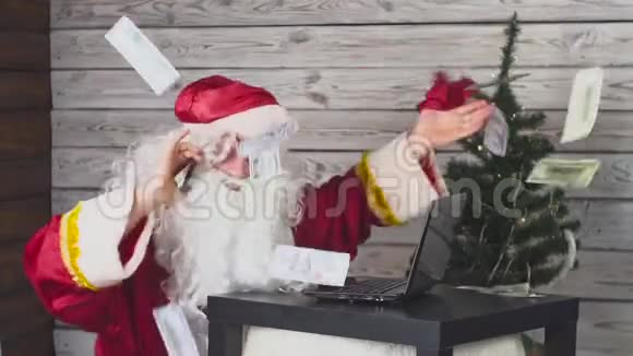 圣诞老人在手机上说话在电脑上工作钱落在他身上视频的预览图