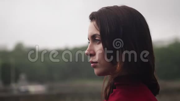 阴晴不定的阴雨天气头发湿漉漉的年轻悲伤的女人望着远方视频的预览图