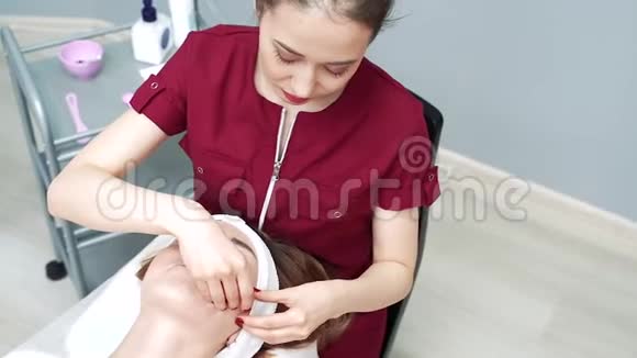 年轻女性做专业的面部手术美容师为女性面部按摩视频的预览图