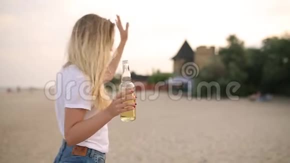 年轻的金发女郎带着酒瓶走向一群朋友的问候和欢呼享受饮料放松自己视频的预览图