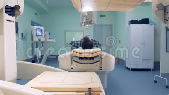 人类躺在磁共振图像设备男性患者躺在一间有工作的CAT扫描仪的病房里视频的预览图