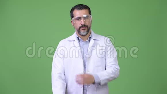 英俊的波斯胡子男医生戴着防护眼镜双臂交叉视频的预览图