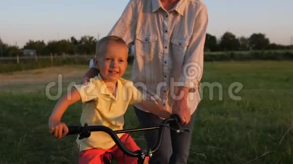特写微笑快乐男孩学习骑自行车视频的预览图