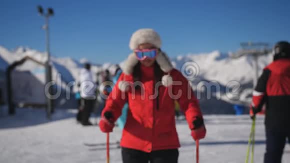 一个滑雪场的女滑雪者走到摄像机前摘下滑雪护目镜视频的预览图