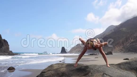 女子在靠近水面的海面上背着海浪做体操瑜伽练习健康的生活方式女人在做什么视频的预览图