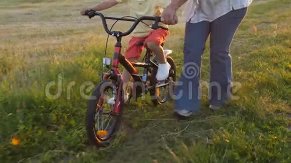 骑自行车的奶奶和男孩的特写腿视频的预览图