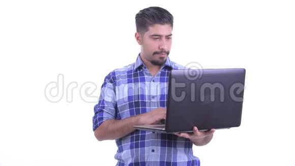 喜欢留胡子的波斯时髦男人在用笔记本电脑思考视频的预览图