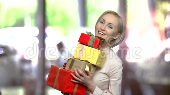 快乐的女人带着一叠礼物盒视频的预览图