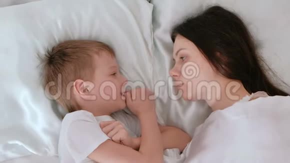 妈妈和儿子醒了妈妈亲吻和拥抱她的儿子视频的预览图