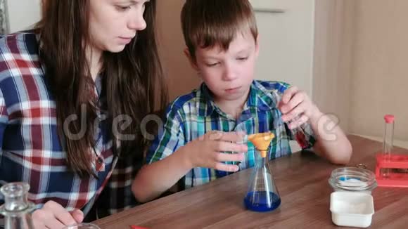 在家做化学实验男孩用漏斗把液体从管子里倒入烧瓶视频的预览图