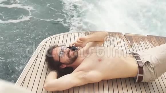 人在阳光下放松躺在海上的船上在岛上的游艇上进行豪华度假视频的预览图